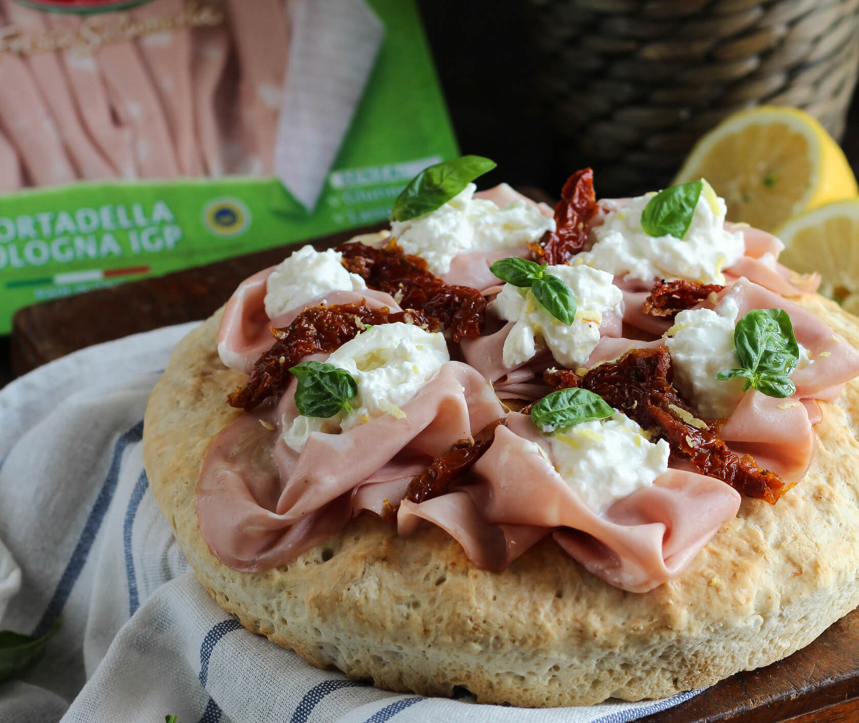 Focaccia con mortadella stracchino, pomodori secchi e limone